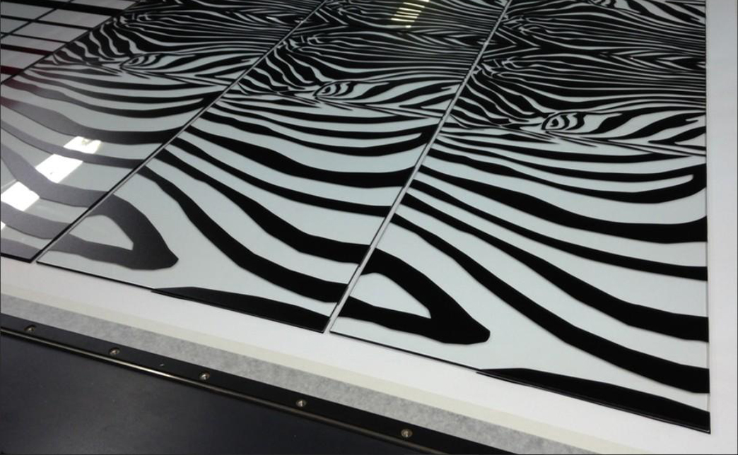 Специальная праймерная обработка поверхности стекла создает микрорельеф, значительно усиливающий адгезию УФ-чернил. Эта технология исключает риск отслоения изображения даже при интенсивной эксплуатации или перепадах влажности. Печать на стекле сохраняет гладкость видимой поверхности.